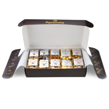 Fully open Popinsanity Gourmet Popcorn Sampler Gift Box presenting all 10 delicious, individually wrapped snack-size gourmet popcorn bags, including Sweet & Salty and Cinnamon Swirl, beautifully arranged within a dark box lined with white gift paper.