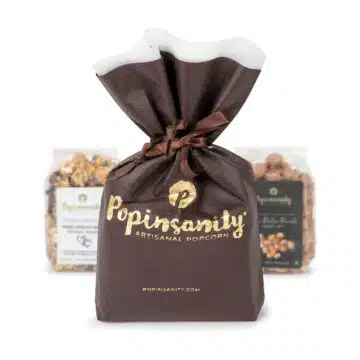 Brown gift bag with gold foil logo and ribbon
