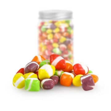 Vivid mix of fruit-flavored candy pieces displayed beside a resealable jar.