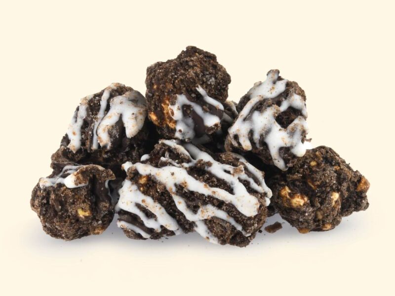 Midnight Fudge Brownie: Intense dark chocolate popcorn clusters with chewy artisan brownie chunks and a glossy fudge shell, topped with a signature white drizzle.